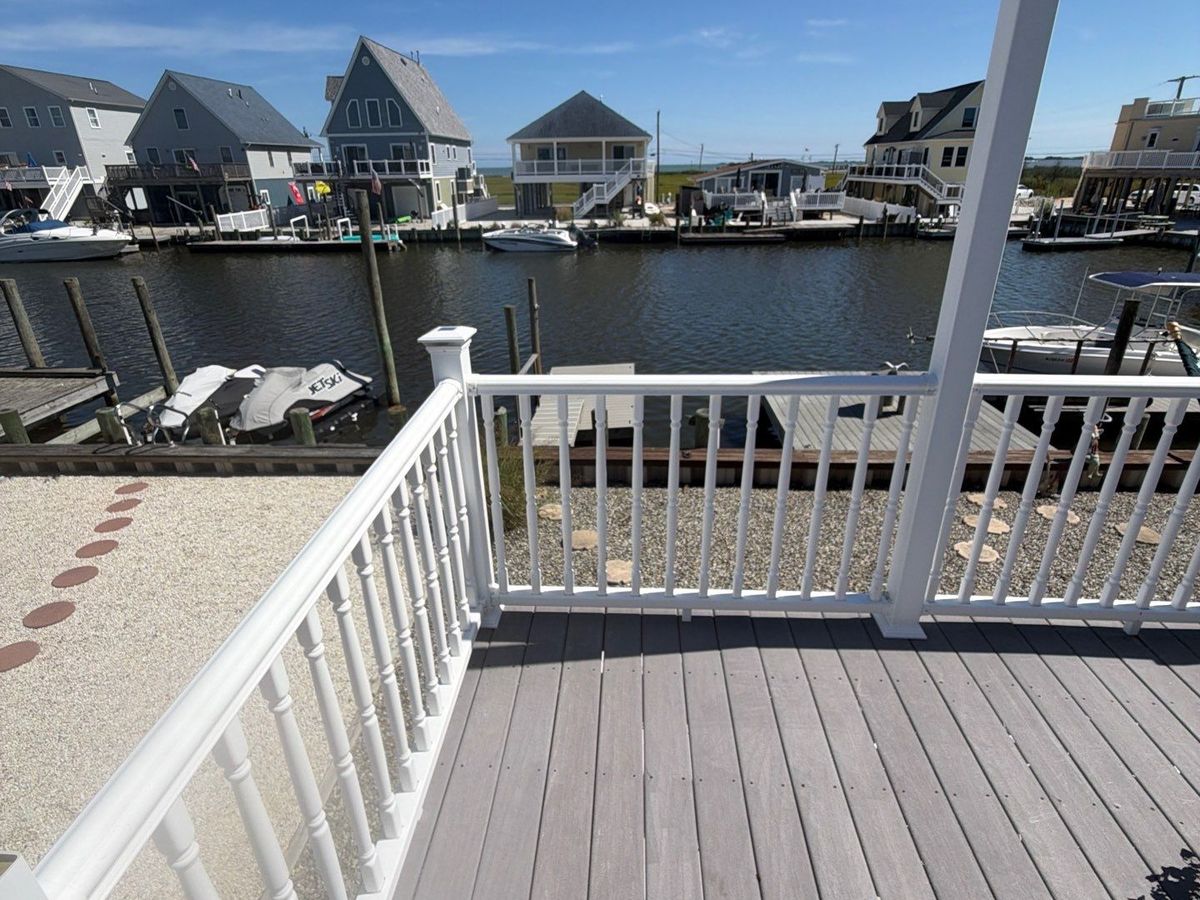 White railing installed on a waterfront deck overlooking a lagoon